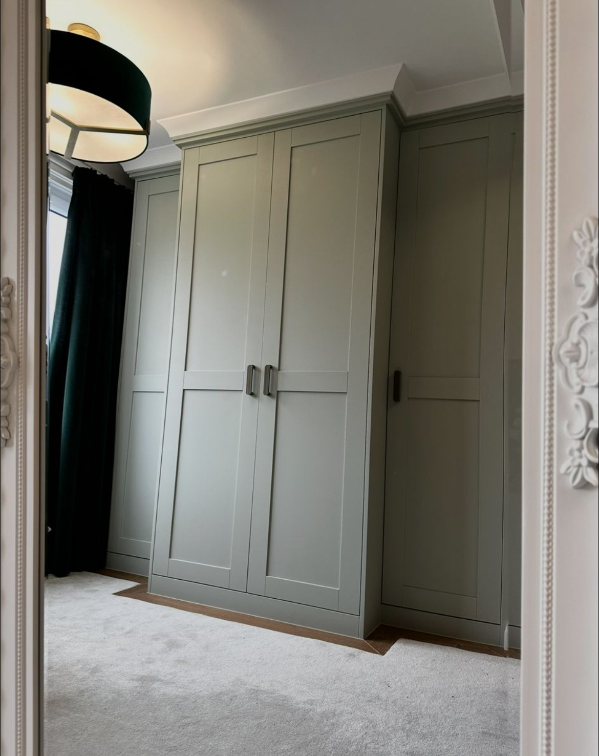 Bespoke fitted wardrobes in soft sage green with shaker doors
